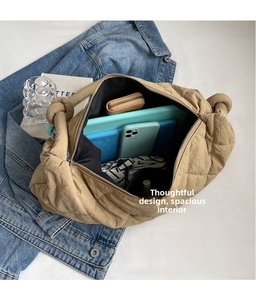 Flat lay of a khaki quilted tote bag showing its spacious interior and knot handle detail