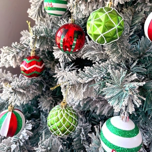 Detailed view of red and green painted Christmas ball ornaments with glitter on tree