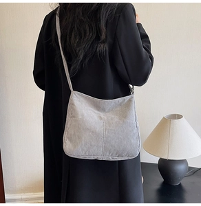 Rear view of model wearing a grey corduroy tote bag with vertical textured stripes