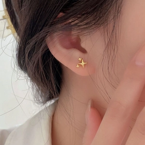Detailed view of 925 sterling silver star stud earrings with a shiny gold finish