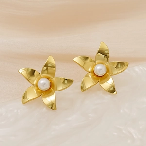 Detailed macro of gold flower stud earrings featuring polished petals and a white pearl center