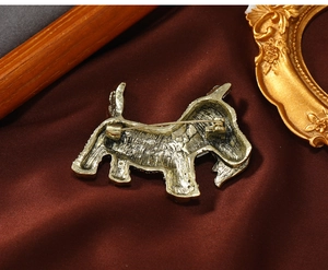 Macro shot of the vintage gold puppy brooch back showing the pin safety rotation clasp