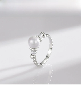 Macro shot of S925 sterling silver pearl ring featuring twisted rope band and glossy finish