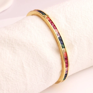 Macro-detail van vergulde regenboogarmband met kanaalgezette vierkante gekleurde zirkoon