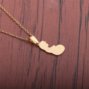 Detailed view of a gold-plated pregnant woman silhouette pendant on a stainless steel chain