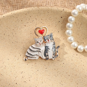 Detail of vintage cat brooch with rhinestones and red heart on a decorative plate