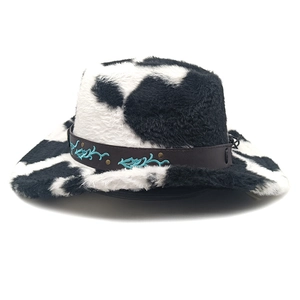 Détail du chapeau de cowboy à motif vache avec bande en cuir et broderie turquoise