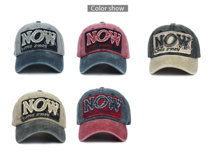 Detail view of five vintage washed cotton baseball caps with embroidered NOW patchwork
