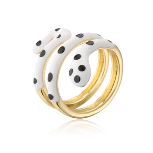 Macro detail of gold-plated snake ring featuring white enamel and black polka dots