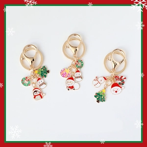 Christmas metal keychains featuring enamel Santa, snowman, and reindeer on gold hardware