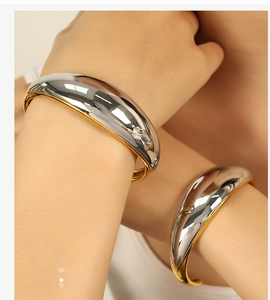 Detail of high-polished mixed metal bangle showing gold and silver contrast on wrist