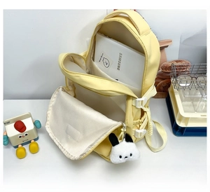 Detail of light yellow backpack showing large main compartment and tablet storage