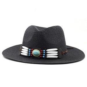 Detail of bohemian black straw hat featuring ethnic beaded band and green turquoise stone