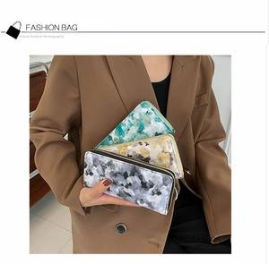 Detail view of long marble pattern wallets with secure zipper closure for women