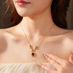 Nahaufnahme der Vintage Goldkette mit rotem ovalem Edelstein und weißen Zirkonia am Model