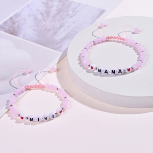 Pink beaded mama and mini bracelet set with heart charms on white display stands