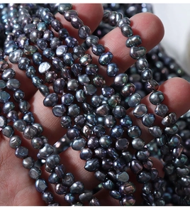 Macro shot of 4-5mm baroque freshwater pearls with colorful peacock green and blue luster