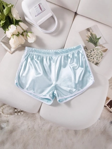 Light blue satin sports shorts with white trim in an elegant flat lay aesthetic