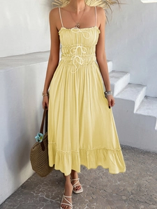 Detail of light yellow sun dress featuring ruched bodice and white tie-up strap accents