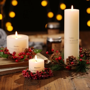 Three white pillar candles with red berry and pinecone wreaths for Christmas decor