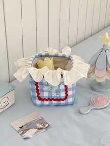 Blue and white plaid laundry basket with cream ruffles and delicate butterfly detail