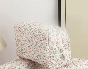 Close-up of pink floral cosmetic bag with a heart-shaped metal zipper puller