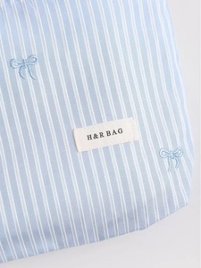 Trousse à maquillage minimaliste à rayures bleu clair avec broderie et étiquette