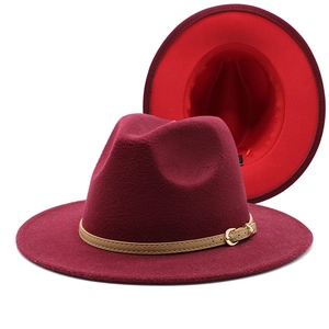 Detail of wool fedora showing burgundy felt, wide brim, and leather strap with gold buckle
