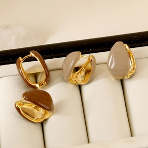 Detailed close-up of French vintage teardrop enamel earrings in brown and beige colors