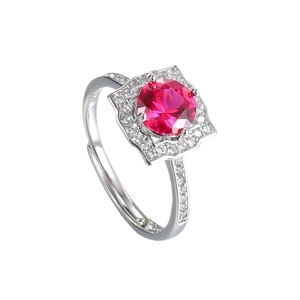 Elegant silver-tone ring with a one-carat red gemstone and diamond halo, sparkling on white