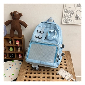 Close-up of light blue nylon school backpack with mesh pockets in a cozy room setting