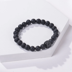 Macro detail of natural black lava stone beads with matte texture and unique square bead