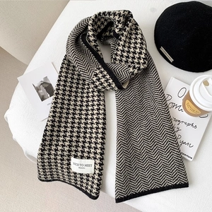 Detail shot of knitted houndstooth scarf with herringbone pattern and brand label