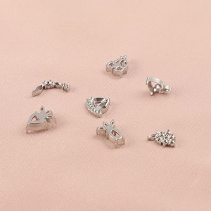 Silver stainless steel charms with small crystals on pink fabric background