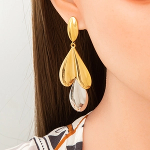 Close-up of elegant 18K gold teardrop earring with large crystal on model