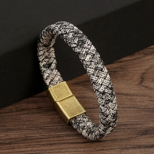 Macro shot of black and white braided leather bracelet with bronze magnetic clasp