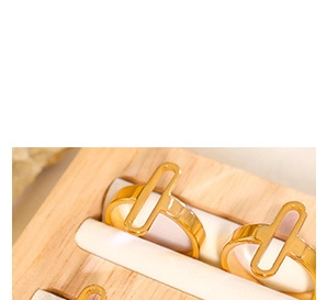 Detailed view of three 18K gold plated titanium rings with T-shape and hollow designs