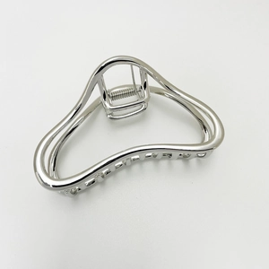 Detailed close-up of a silver geometric hollow metal hair claw clip with spring view