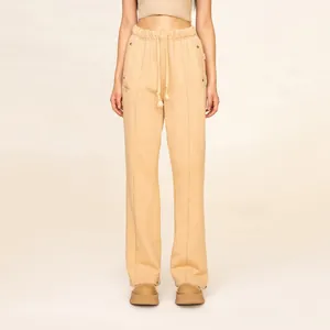 Detail of beige drawstring waistband with decorative stitching and metal rivet on casual pants