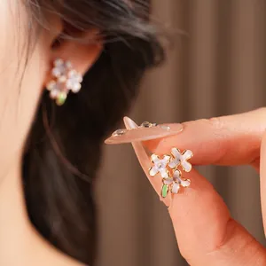 Elegante lila Blumenohrstecker mit Goldrand und grünem Blattdetail für Damen