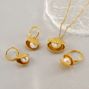 Detailed view of elegant gold shell and pearl jewelry set with necklace and earrings