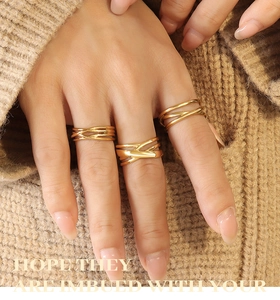 Close-up of three-piece gold geometric layered rings with minimalist twisted design