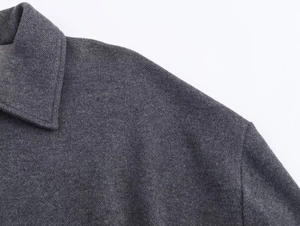 Detailed macro shot of dark grey twill fabric texture and collar stitching on jacket