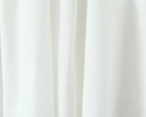 Close-up of white fabric texture showing the natural drape and fine plain weave detail