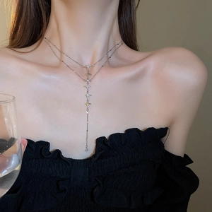 Detail of silver double-layered star pendant necklace worn by a model in a lifestyle setting