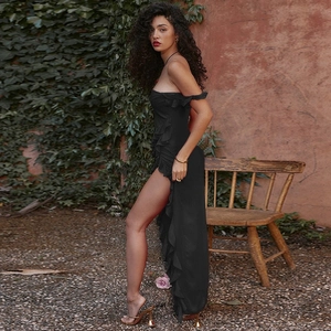 Black off-shoulder dress featuring ruffled details and a high side slit shown on a model