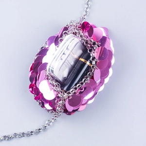 Detail view of pink sequin chain bag showing internal capacity for earphones and lipstick