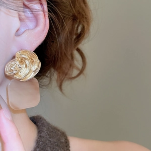 Macro view of geometric shell-textured metal and square acrylic pendant earrings