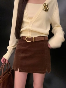 Detail view of caramel brown corduroy mini skirt with vintage belt and texture detail