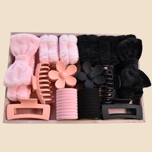 Flat lay of pink and black spa headband set with wristbands, hair clips and hair ties
